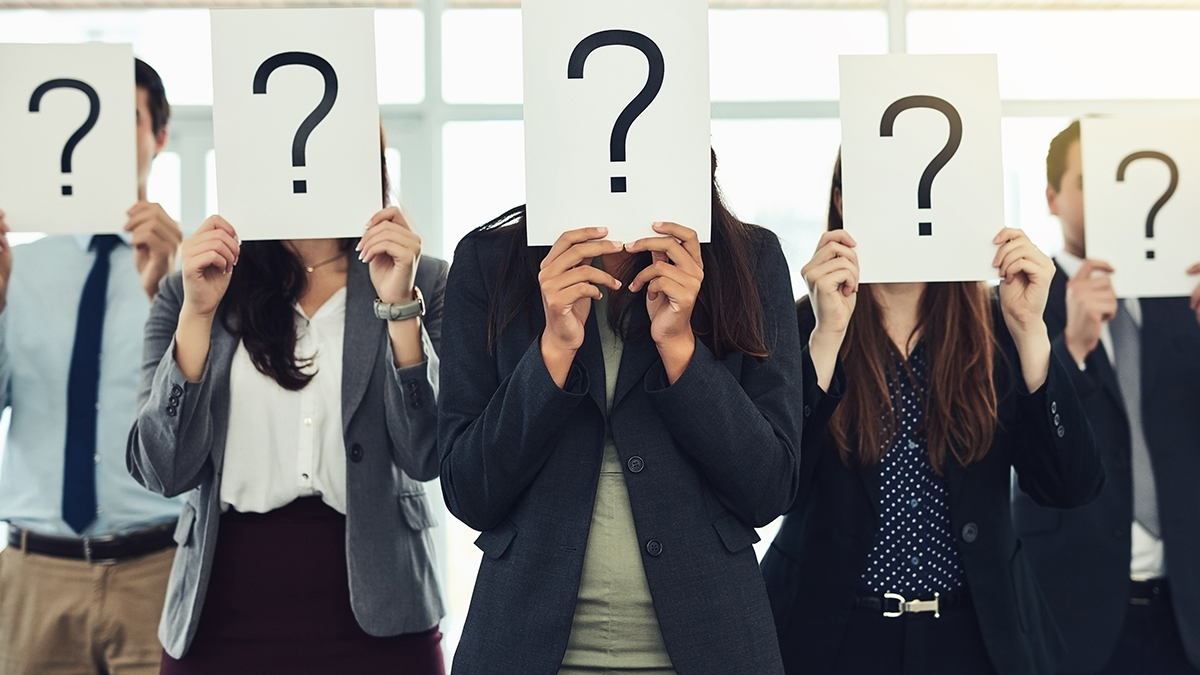 Shot of a group of businesspeople holding questions marks in front of their faces