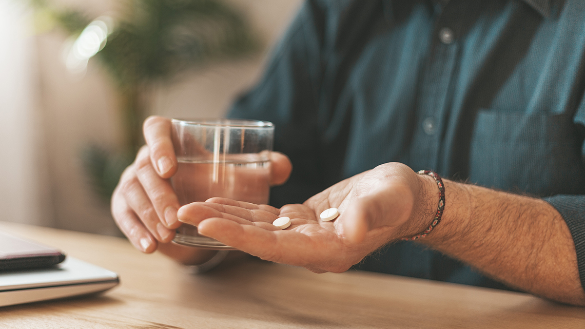 Senior taking medication with water