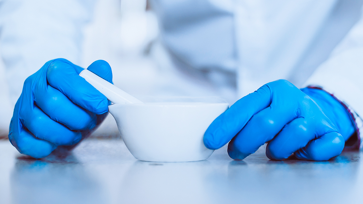 gloved hands with mortar and pestle