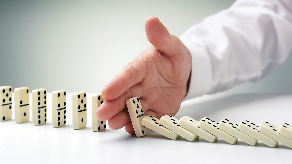 hand stopping dominos