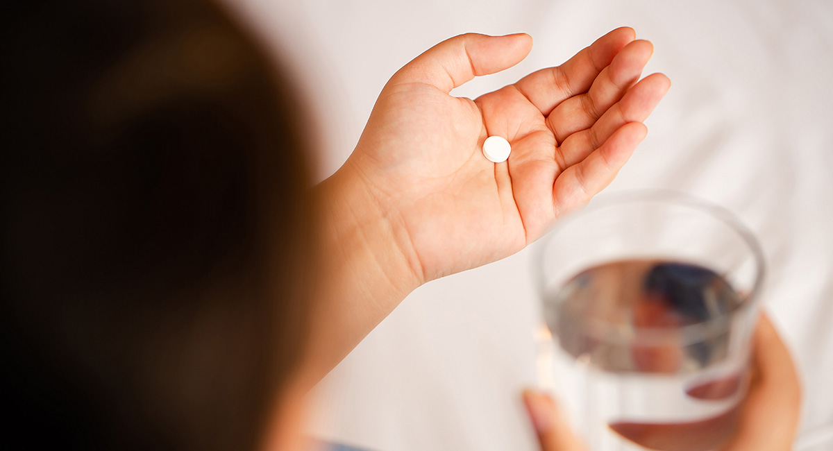 person taking medication with water