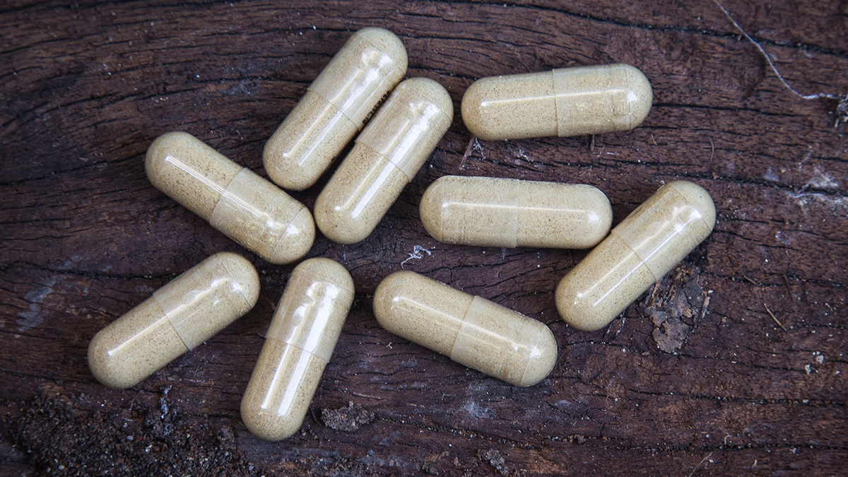 capsule pills on wooden background