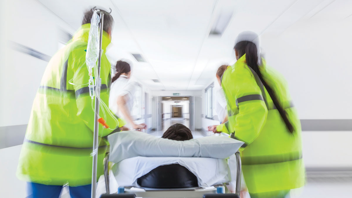 patient on stretcher or gurney being pushed at speed through a hospital