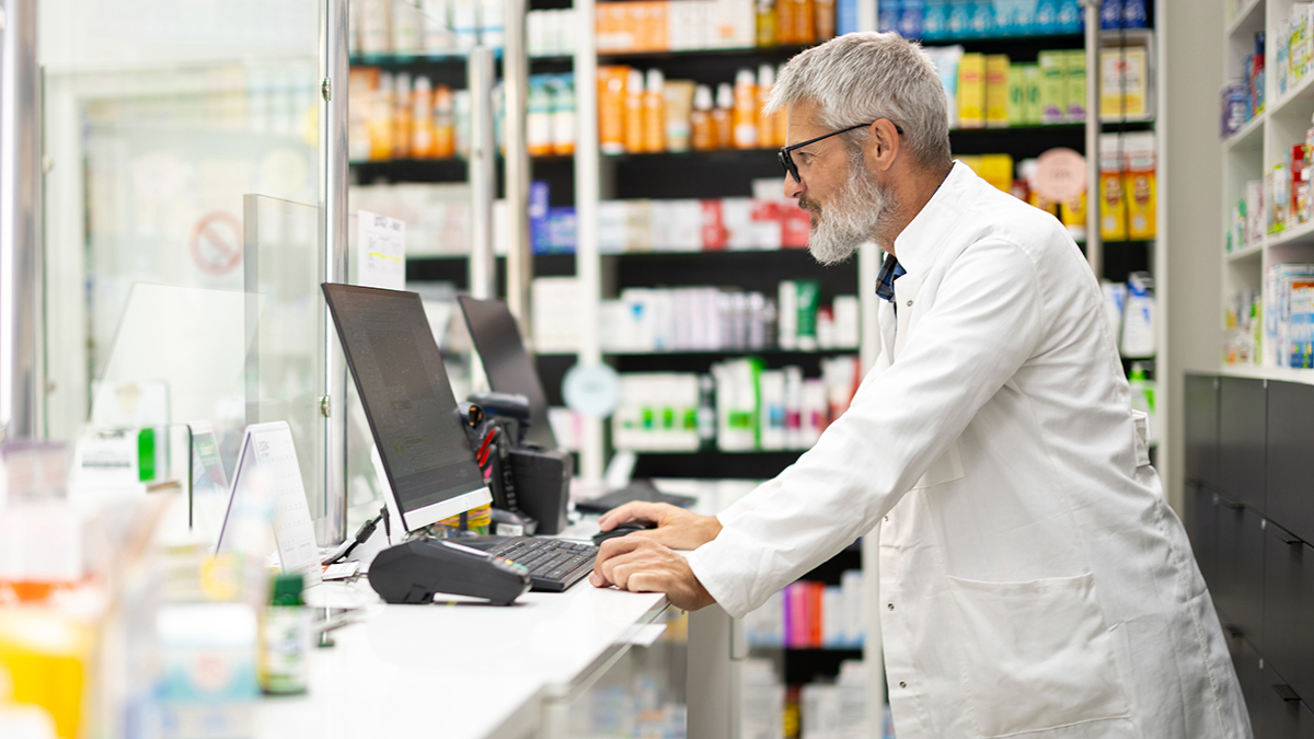 Pharmacist working on the computer at the pharmacy counter